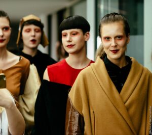 Main Subject: A group of fashionably dressed people, possibly models, in a lineup